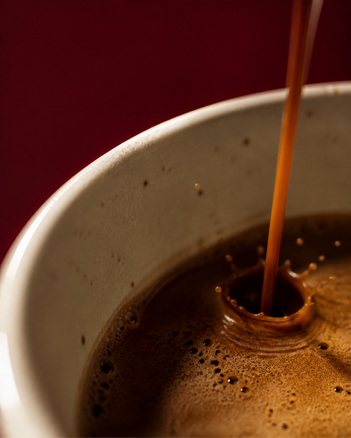 Detalle de espresso cayendo sobre crema